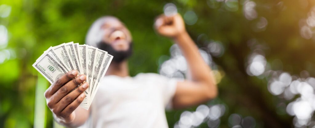 black-man-holding-money-shutterstock_2482835011_Prostock-studio-scaled.jpg